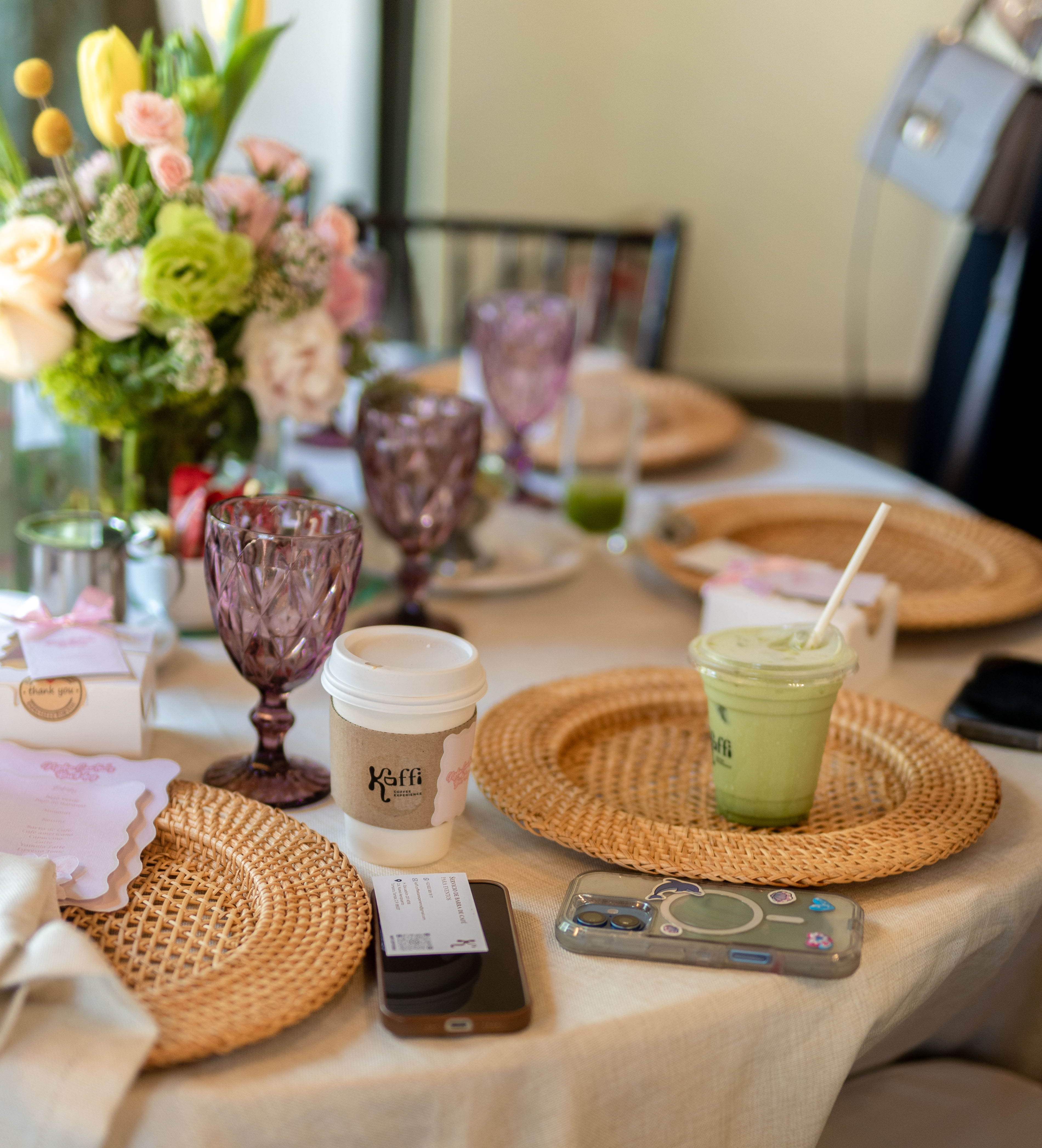 Mesa elegante con bebidas Kaffi y arreglo floral